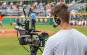 Photo by Andy McEvoy - Evan Martyniuk, one of the interns for The Creative Outpost, works a camera during a summer Diamond Dawgs baseball game.