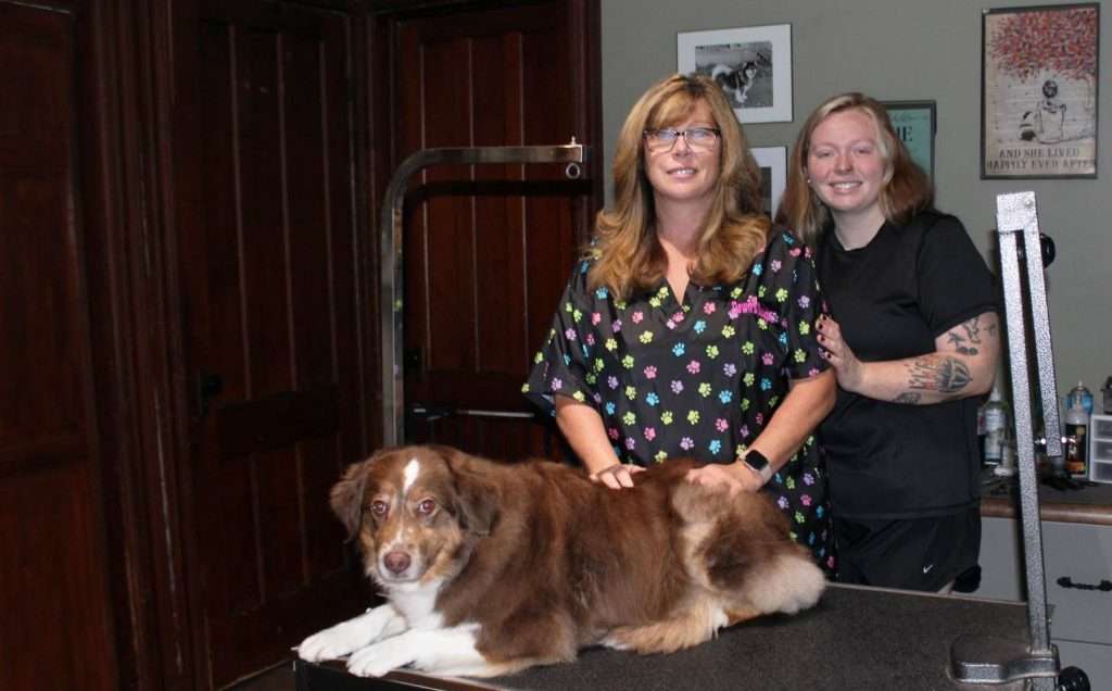 Dawn Glode (left) with her daughter Kacey Daley (right) and Brandi at Dawn’s Dawgs grooming shop.